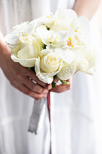 与白玫瑰和兰花的婚礼花束