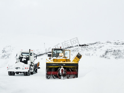 挖掘机雪铲卡车在雪路上工作，挪威。