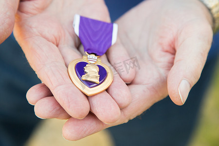 他手里拿着军事紫心勋章的老人。
