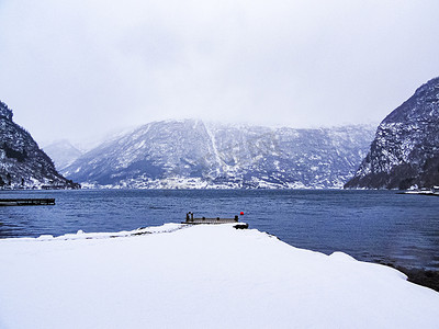 冻脚摄影照片_挪威峡湾湖冬季景观中的码头。