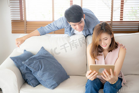 亚洲年轻夫妇在互联网上放松看平板电脑娱乐