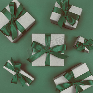 用带有绿色丝带和蝴蝶结的牛皮纸包裹的礼品盒。