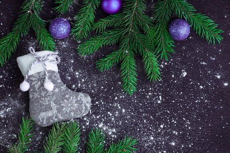 雪地黑色背景上带紫色的灰色圣诞袜