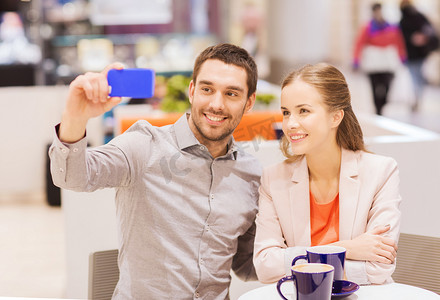 幸福的夫妻在商场里用智能手机自拍