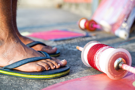 在印度 makar sankranti uttarayana 节上，年轻人穿着橡胶拖鞋，带 charkhi fikri 线轴，带 dor 线，带玻璃线，风筝放在附近