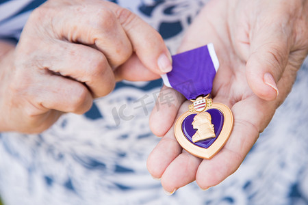 她手里拿着军事紫心勋章的高级妇女