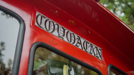 Coyoacan 标志在一辆红色电车上，背景是模糊的树木