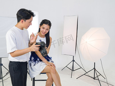 亚洲摄影师允许模特查看相机屏幕上拍摄的照片。