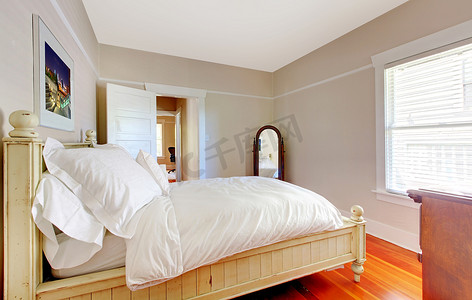 有白色床和米黄墙壁的明亮的卧室。