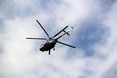 直升机在蓝色多云的天空中飞行