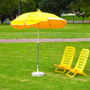 黄色的雨伞和躺椅站在草地上