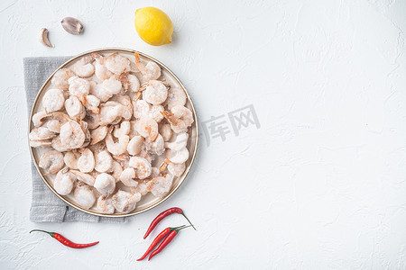 虾群摄影照片_煮熟和冷冻的虾，在盘子里，在白色背景上，顶视图平躺，有文本的复制空间