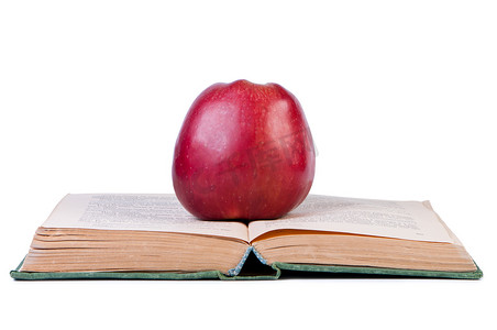 在打开的旧书上的苹果。