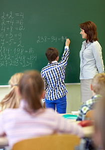 老师和小学生在粉笔板上写字