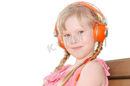 扎辫子女孩摄影照片_扎辫子的女孩在耳机隔离中听语言课