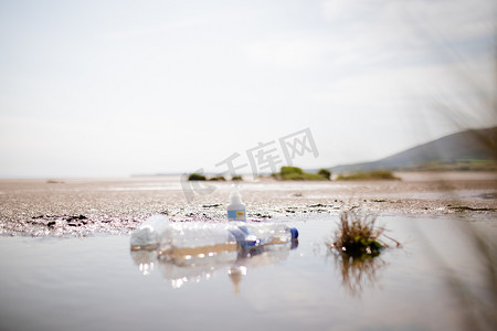 沙子中间水坑里的几个空塑料瓶