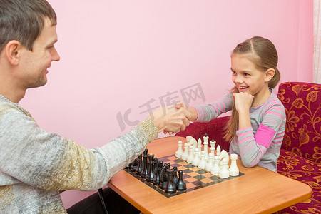 打招呼摄影照片_爸爸和女儿互相打招呼，准备下棋