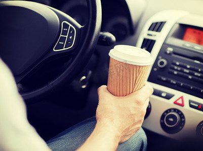 开车时喝咖啡的男人
