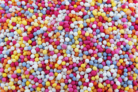 粉色小糖果摄影照片_成千上万的小糖珠洒在蛋糕和甜点的背景纹理上