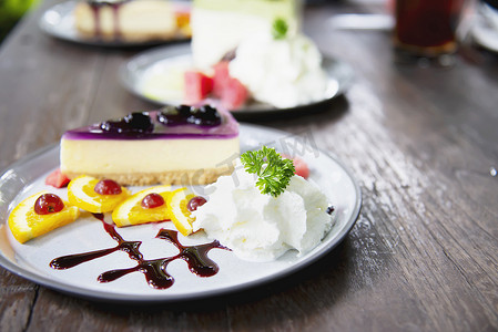 五颜六色的芝士蛋糕蓝莓配上装饰精美的水果片和白盘中的鲜奶油 — 蛋糕食谱菜单概念