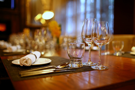 桌子上的空盘子摄影照片_餐厅桌子上的盘子和玻璃杯
