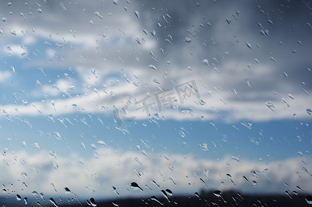 灰色斑点背景摄影照片_窗户上的雨滴