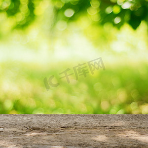 绿色背景桌面摄影照片_明亮的绿色背景花园中的空木桌