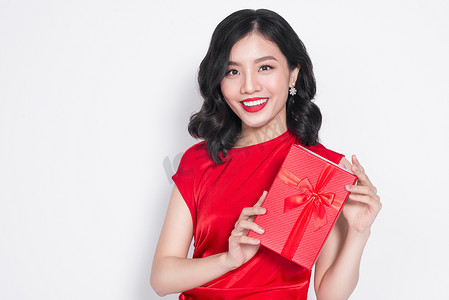 身着红色连衣裙、带着礼物的漂亮年轻亚洲女人