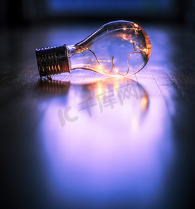 led灯带摄影照片_想法和创新：带 LED 的灯泡躺在木地板上。