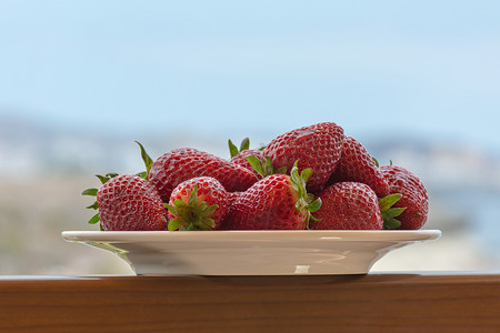 洗草莓草莓摄影照片_在盘子上的红色成熟草莓。