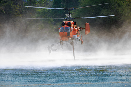 消防直升机在池塘上空盘旋补水