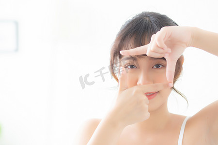 护肤品化妆品摄影照片_美丽的亚洲年轻女性眼部皮肤护理和手势框