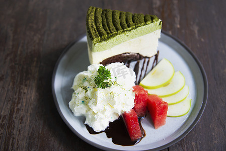 五颜六色的绿茶蛋糕配上装饰精美的水果片和白盘生奶油 — 蛋糕食谱菜单概念