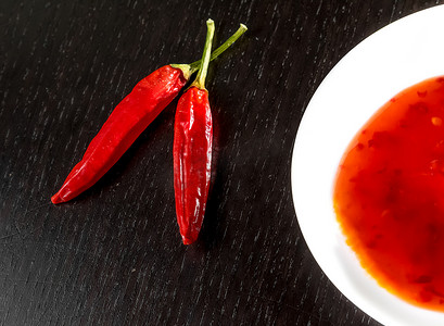 玉米的地摄影照片_辛辣的热番茄酱作为小吃或开胃菜，放在靠近辛辣辣椒的白盘中