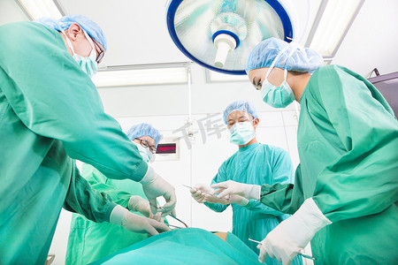 牙科手术台摄影照片_在手术室工作的团队外科医生。