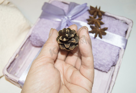 一个女人的手用金锥装饰圣诞礼物，打包毛巾，并为假期做准备