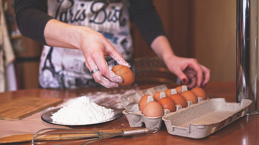 一位女厨师在做面包时挑选鸡蛋做面团的手
