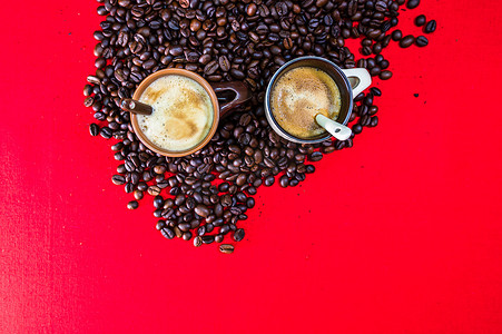 咖啡豆红色摄影照片_一杯咖啡，红色背景中的烤咖啡豆，顶视图，