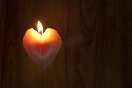 黑暗蜡烛摄影照片_蜡烛形状的心