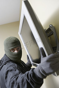 小偷从家里抢劫平板电视