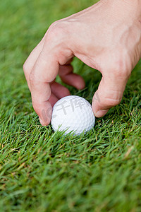 高尔夫上杆摄影照片_绿草上的高尔夫球和铁杆细节宏观夏季户外