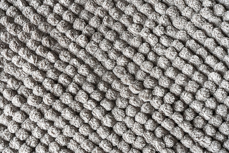地毯花纹图案摄影照片_由小球制成的灰色毯子的质地。