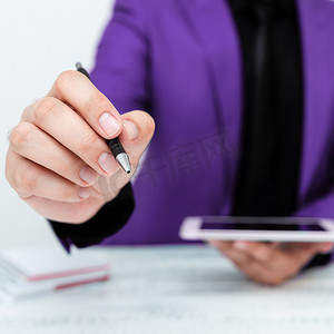 穿着紫色夹克的男人坐在白桌旁，用笔指着重要信息。