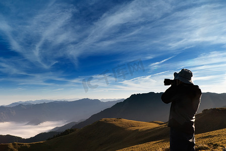 一位摄影师站在户外拍摄蒙山云。