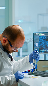 在现代设备齐全的实验室中使用微移液器填充试管的男科学家