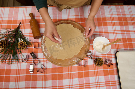 俯视厨师糖果师的手在擀好的面团上撒面粉，为圣诞节做姜饼