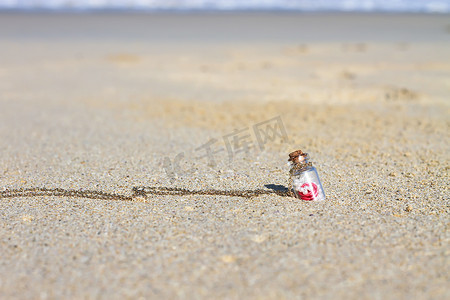 白色沙滩背景绿松石海中的小瓶