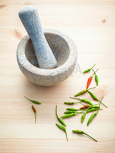 钵摄影照片_白色木制背景上的新鲜辣椒，配有研钵和研杵