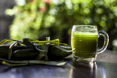 黑色表面玻璃杯中的丝瓜或 Galka 或丝瓜蔬菜的鲜汁。