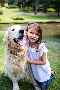 微笑的女孩和她的宠物狗在公园里